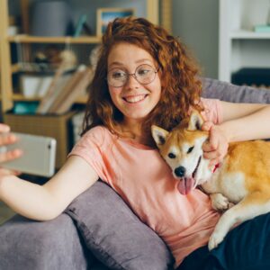 a woman sitting on a couch holding a dog
